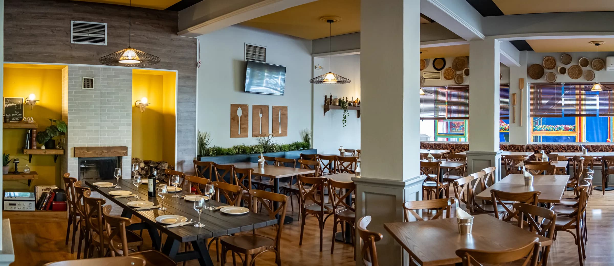 The enclosed indoor dining room, with its fireplace and wooden tables